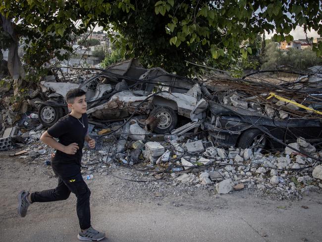 A boy runs past cars destroyed in a recent Israeli strike in Mays Al-Jabal, Lebanon. Picture: Getty Images