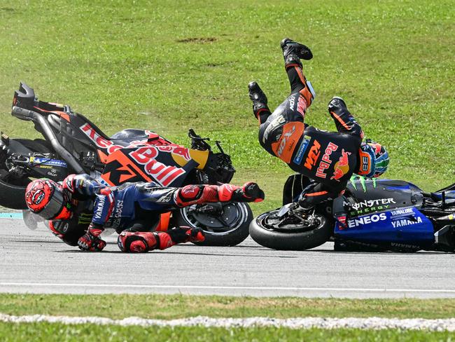 Monster Energy Yamaha MotoGP's French rider Fabio Quartararo (L) and Red Bull KTM Factory's South African rider Brad Binder (R) fall after a collision during the MotoGP Malaysian Grand Prix at the Sepang International Circuit in Sepang on November 3, 2024. (Photo by MOHD RASFAN / AFP)