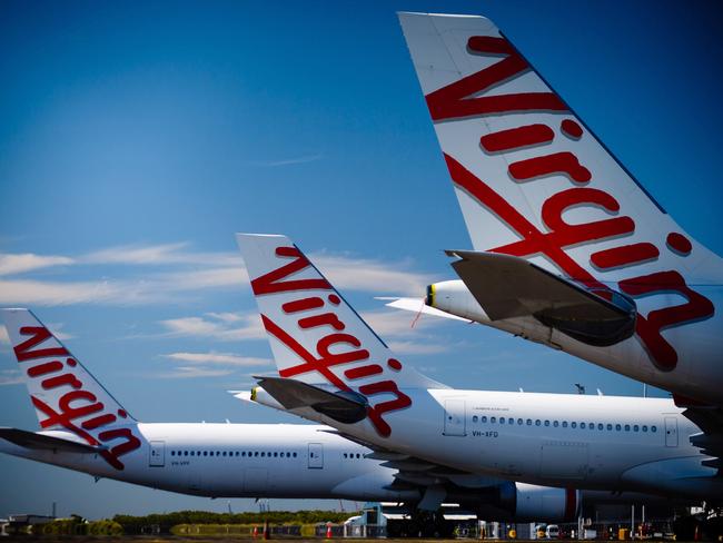 Virgin Australia aircraft are seen parked on the tarmac at Brisbane International airport on April 21, 2020. - Cash-strapped Virgin Australia collapsed on April 21, making it the largest carrier yet to buckle under the strain of the coronavirus pandemic, which has ravaged the global airline industry. (Photo by Patrick HAMILTON / AFP)