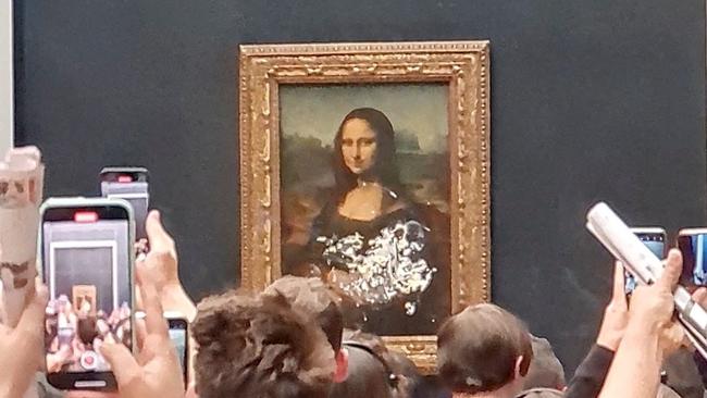 Visitors take pictures and video of the painting "Mona Lisa" after custard pie was smeared on the protective glass at the Louvre Museum in Paris, France May 29, 2022. Picture: X