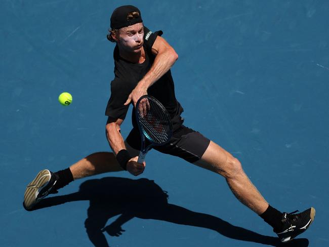 TOPSHOT - Australia's Dane Sweeny hits a return against Argentina's Francisco Cerundolo during their men's singles match on day one of the Australian Open tennis tournament in Melbourne on January 14, 2024. (Photo by Martin KEEP / AFP) / -- IMAGE RESTRICTED TO EDITORIAL USE - STRICTLY NO COMMERCIAL USE --