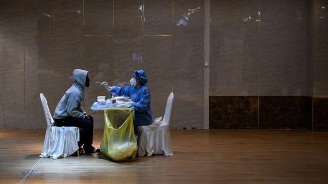 A health worker takes a swab sample from a journalist to be tested for Covid-19. Picture: AFP