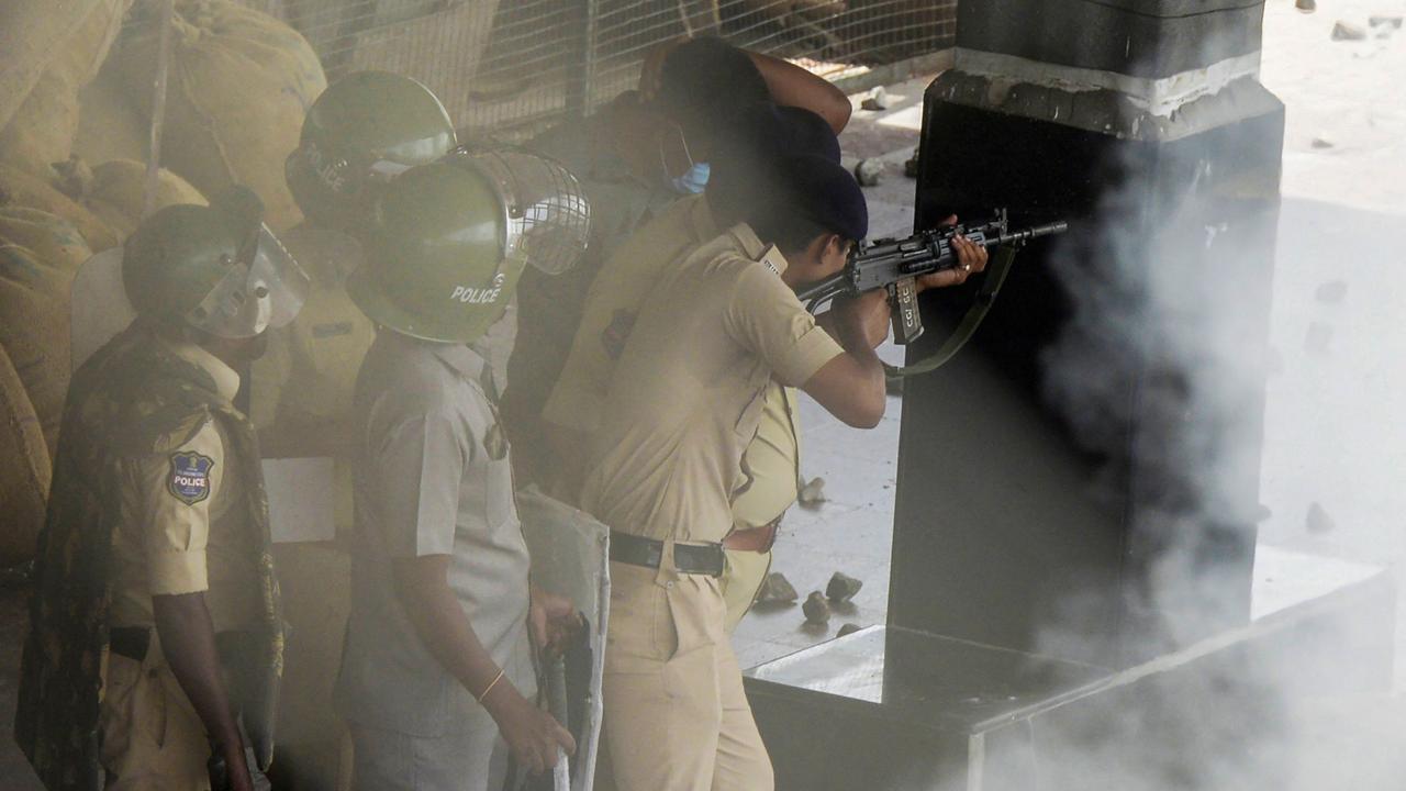 Policemen open fire to disperse protesters during a demonstration. Picture: Noah Seelam / AFP