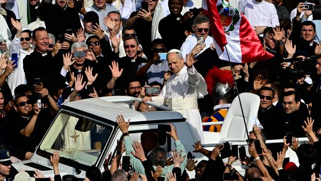Pope Leo XIV greets the crowd from the popemobile before the mass. Picture: AFP