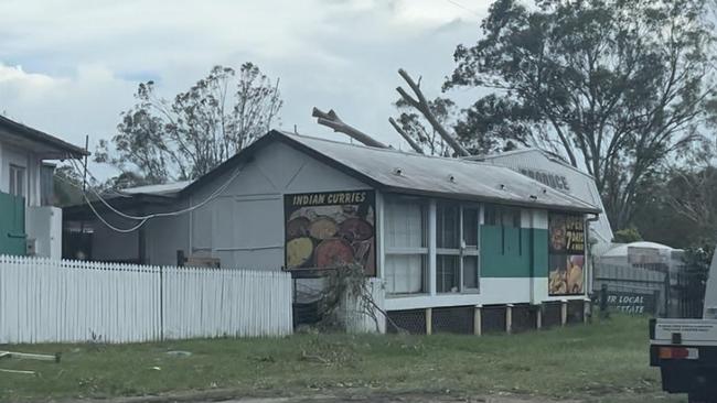 Powerlines remain severely damaged in Tamborine Village. Produce store destroyed by tree after Christmas Day storms