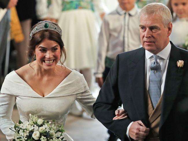 TOPSHOT - Britain's Princess Eugenie of York (L) walks up the aisle with her father Britain's Prince Andrew, Duke of York, (R)  to marry Jack Brooksbank during their wedding ceremony in St George's Chapel, Windsor Castle, in Windsor, on October 12, 2018. (Photo by Yui Mok / POOL / AFP)