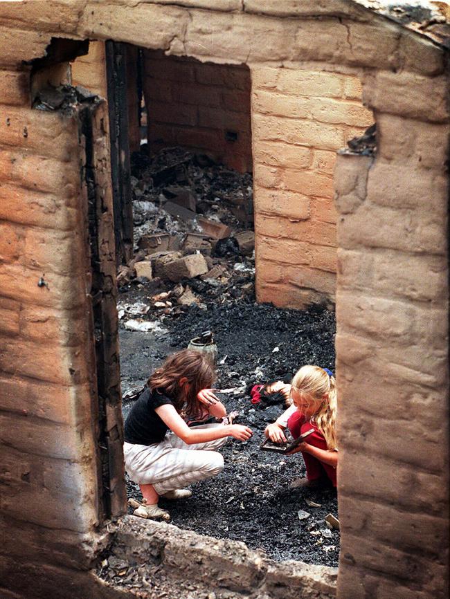 Lauren Jamieson and Bianca Elward search for jewellery in the remains of a gutted Alpine Rd home.