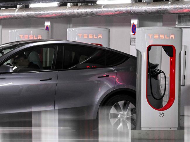 A Tesla electric car is charged at a charging station at a car park in Berlin, Germany on August 3, 2023. Tesla reported a jump in second-quarter profits on July 19 as a series of price cuts translated into sharply higher car sales. Elon Musk's electric vehicle company reported profits of USD 2.7 billion, up 20 percent on the year-ago level. (Photo by Ina FASSBENDER / AFP)