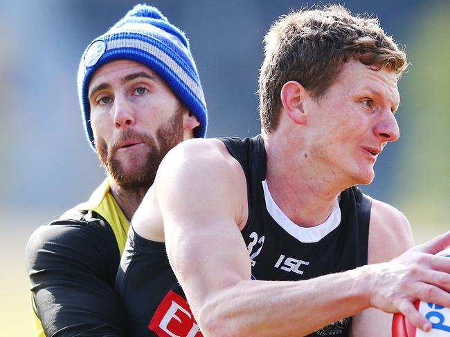 MELBOURNE, AUSTRALIA - JULY 12: Jeremy Howe of the Magpies tackles Will Hoskin-Elliott of the Magpies Nathan Buckley speaks to the media during a Collingwood Magpies AFL press conference at the Holden Centre on July 12, 2018 in Melbourne, Australia.  (Photo by Michael Dodge/Getty Images)