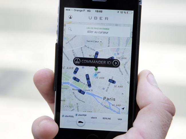 (FILES) -- A file photo taken on June 17, 2015 shows a person using the French version of the Uber app to order a UberPop cab in Paris. Uber has suspended its controversial UberPOP service in France, the group's spokeman announced on July 3, 2015. AFP PHOTO / THOMAS OLIVA