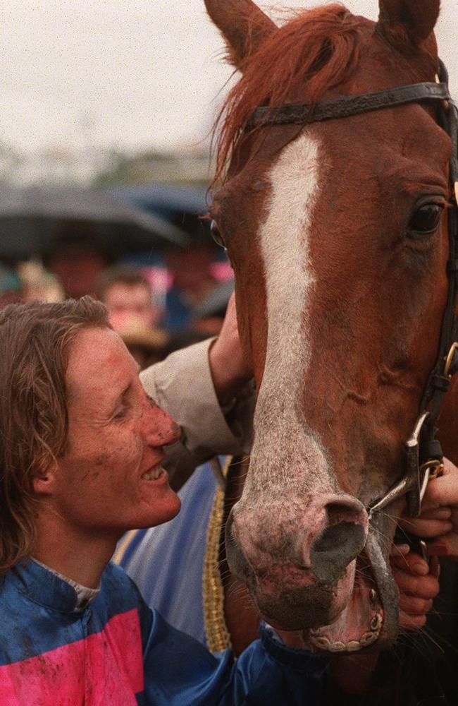 A mud-spattered Damien Oliver unsaddles Doriemus.