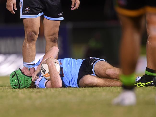 Northern Sharks fullback Caleb Smith goes down after a huge hit from Palmerston Raiders in the NRLNT Grand Final 2022. Picture: (A)manda Parkinson