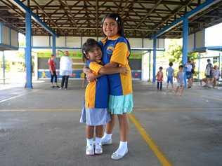 SISTERS IN ARMS: Erika and Emily Williams try their new Mt Archer School uniforms on for size, eagerly waiting for school to start next week. Picture: Jann Houley