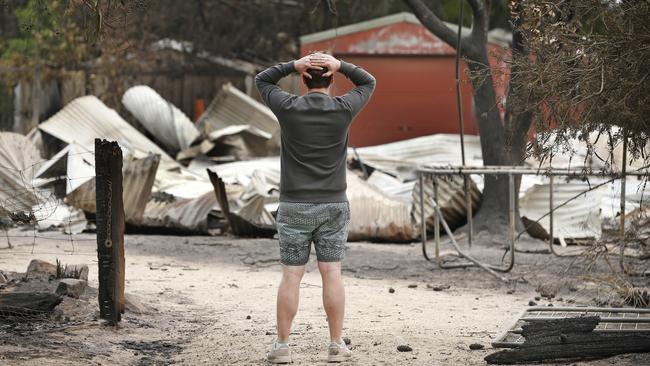 A local’s despair at a home lost in Mallacoota. Picture: David Caird