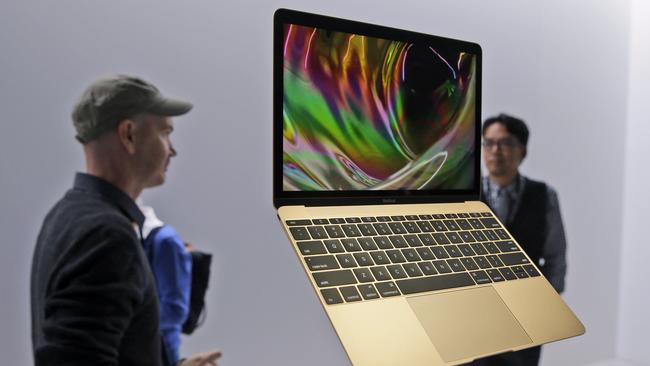 FILE - In this March 9, 2015 file photo, members of the media and Apple guests get a look at the new MacBook in the demo room after an Apple event in San Francisco. The company will debut the new laptop on Friday, April 10, 2015. (AP Photo/Eric Risberg, File)