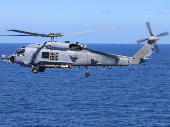 A Royal Australian Navy MH-60R Seahawk helicopter from 816 Squadron, Nowra, drops a Mark 54 Lightweight Hybrid Torpedo, during a recoverable torpedo exercise, off the coast of Jervis Bay, New South Wales. *** Local Caption *** 816 Squadron is Navy's operational support squadron for the MH-60R 'Romeo' maritime combat helicopter. The squadron can deploy up to eight flights embarked in Navy's fleet of Hobart class destroyers and Anzac class frigates, providing a ship or task group with an enhanced anti-submarine and anti-surface warfare capability. The crew, consisting of the Aircraft Captain, Mission Commander and Sensor Operator, combine to maximise the employment of the Romeo.