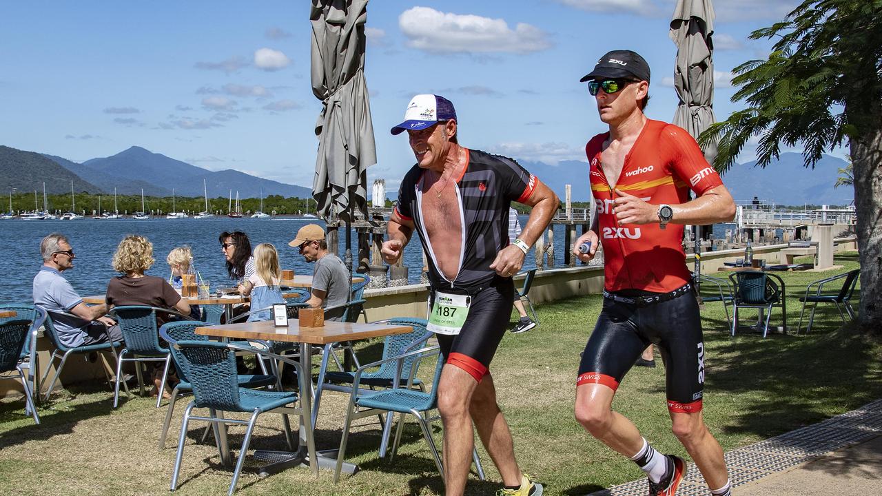 Cairns Iron Man - ONE FOR THE POOL ROOM - Whitfield local from 'Team Lungs of Steel' keeps pace with race champ Max Neumann on the water front during the run leg. Picture: Brian Cassey