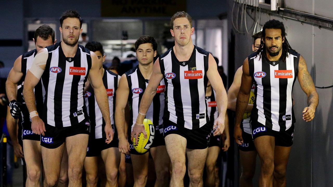 Heritier Lumumba (right) walks on to the MCG with his Collingwood teammates. Picture: George Salpigtidis