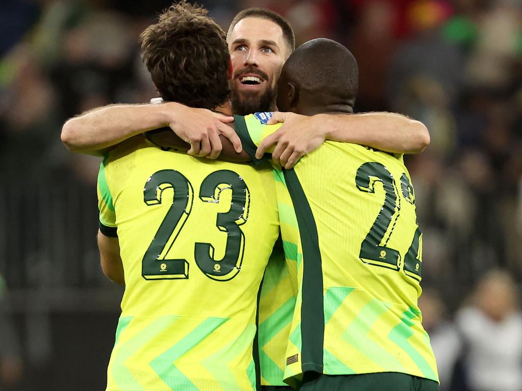 Alessandro Circati (23) celebrates the Socceroos’ 1-0 win over Japan with teammates Milos Degenek (left) and Jason Geria. Picture: Colin Murty / AFP