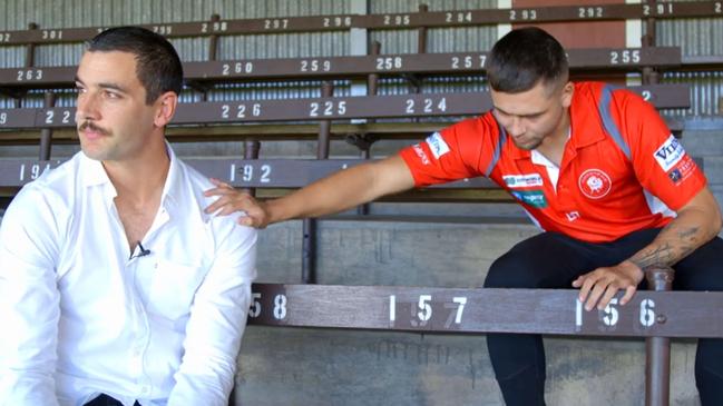 North Adelaide’s Robbie Young (right) consoles Crow Taylor Walker during his public apology on Monday. Picture: AFC