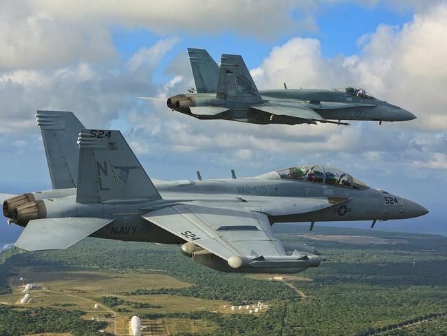 An E/A-18G Growler from the United States Navy (front), and a No 3 Squadron F/A-18 Hornet from the Royal Australian Air Force fly in formation as they return to Andersen Air Force Base. Picture: Commonwealth of Australia