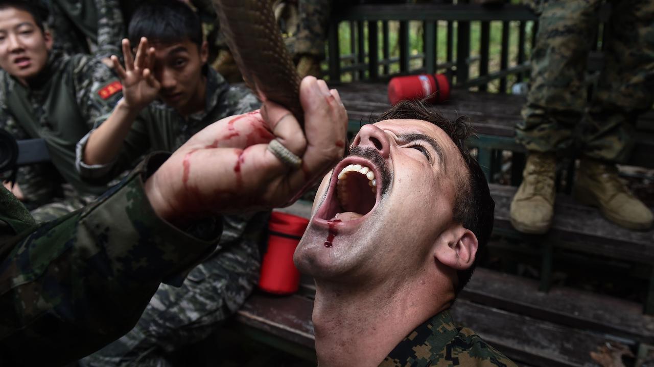 A marine drinks cobra blood during exercises in Thailand. Picture: Lillian Suwanrumpha/AFP