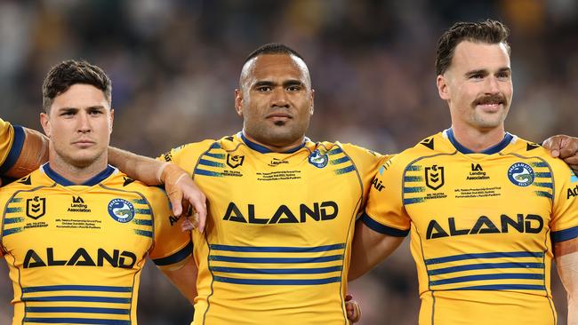 Mitchell Moses, Junior Paulo and Clinton Gutherson of the Eels line up for the national anthem during the 2022 NRL Grand Final match between the Penrith Panthers and the Parramatta Eels at Accor Stadium on October 02, 2022, in Sydney, Australia.