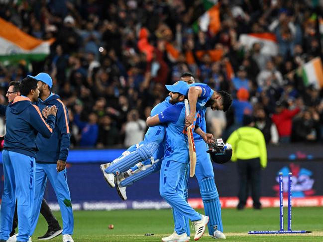 India's Captain Rohit Sharma (C) lifts Virat Kohli as they celebrate after a win during the ICC men's Twenty20 World Cup 2022 cricket match between India and Pakistan at Melbourne Cricket Ground (MCG) in Melbourne on October 23, 2022. (Photo by WILLIAM WEST / AFP) / -- IMAGE RESTRICTED TO EDITORIAL USE - STRICTLY NO COMMERCIAL USE --