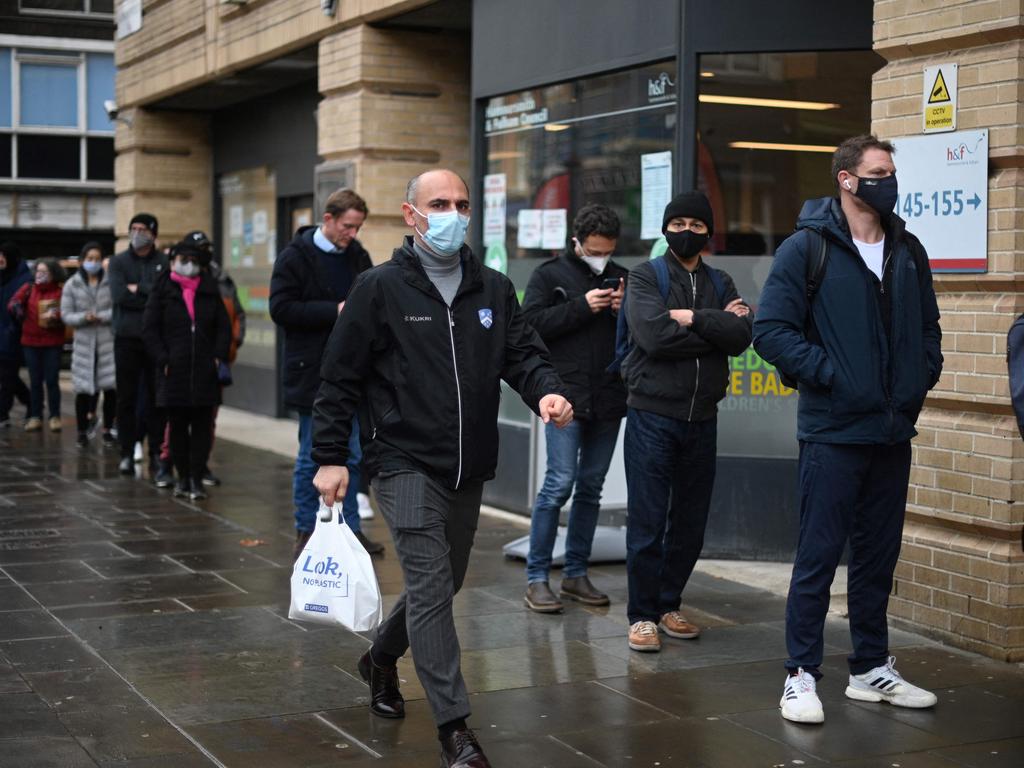 People wait in a queue outside a pop-up vaccination centre for the Covid-19 vaccine or booster, in Hammersmith and Fulham in Greater London as rollout accelerates in England. Picture: AFP