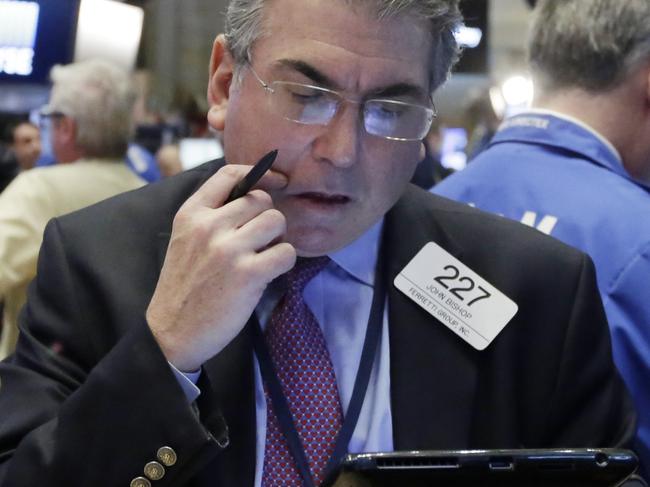 Trader John Bishop works on the floor of the New York Stock Exchange, Wednesday, Feb. 3, 2016. The stock market has given up an early gain and is trading lower at mid-morning Wednesday as investors give a thumbs-down to a number of corporate earnings reports, including steep cutbacks at Yahoo. (AP Photo/Richard Drew)