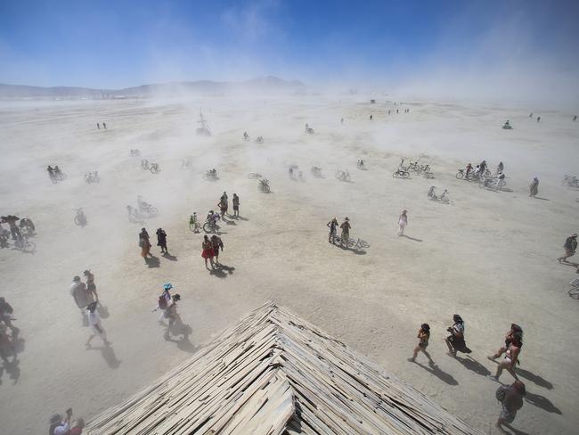 Festivalgoers approach the Catacomb of Veils art installation as dust kicks up along the playa during Burning Man this month. Picture: AP