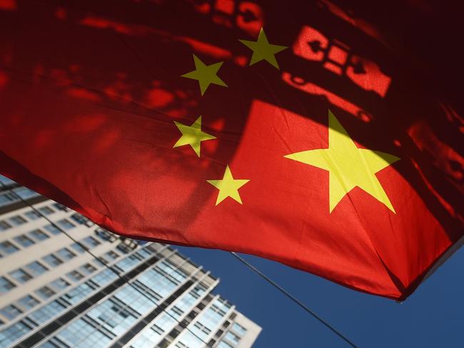 (FILE) This file photo taken on September 11, 2015 shows a Chinese flag flying near apartment buildings in Beijing.  Chinese household debt has risen at an "alarming" pace as property values have soared, analysts say, raising the risk that a real estate downturn could send shockwaves through the world's second largest economy. / AFP PHOTO / GREG BAKER