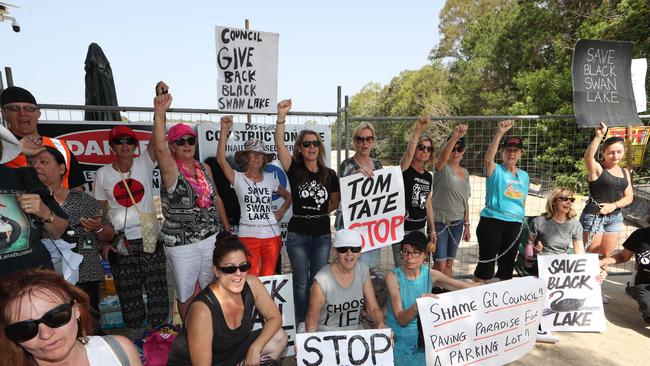 Black Swan Lake protest at Bundall goes to another level, with protesters chaining themselves to the fence and then getting themselves arrested after running onto the worksite and stopping the trucks … Picture Glenn Hampson