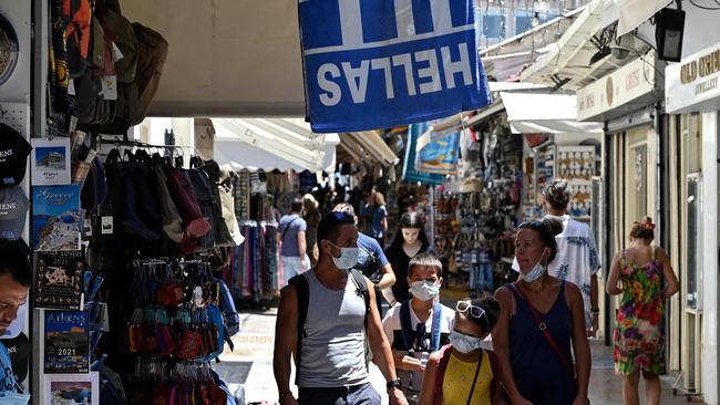 Tourists wearing protective face masks walk in Athens' main commercial district. Picture: AFP.