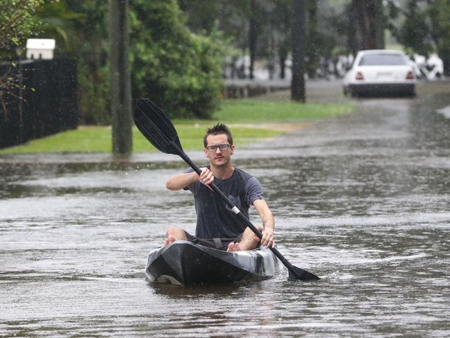 Harrison Orth. paddles down the flooded Corella St in Rocklea, Brisbane. Picture: Darren England