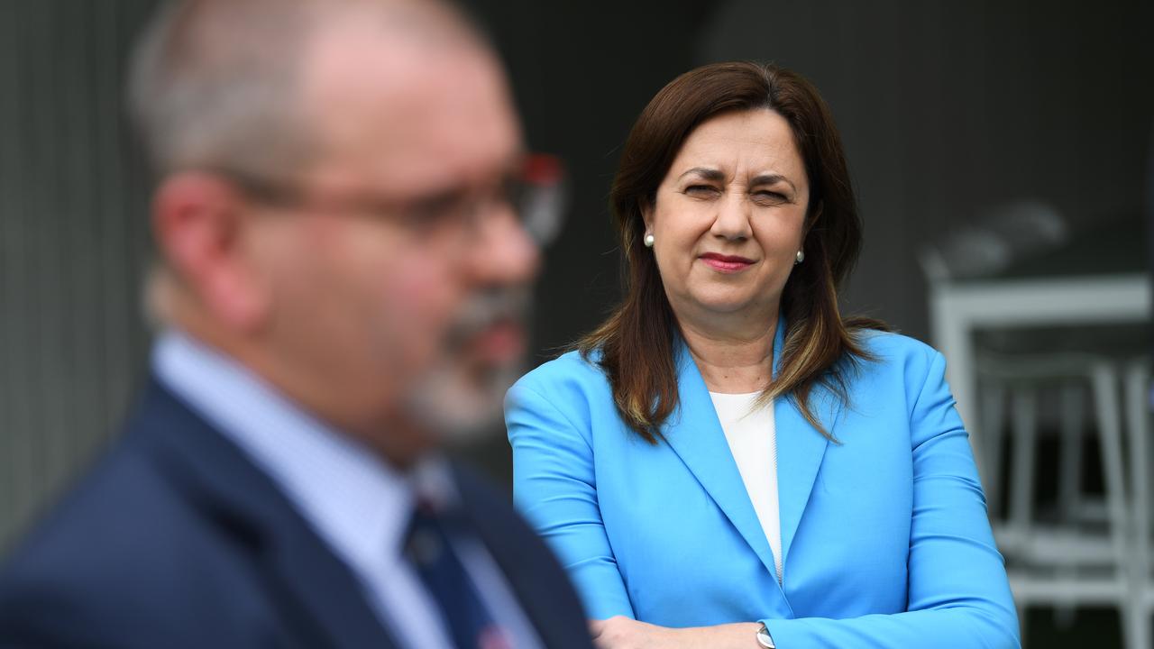 Queensland Premier Annastacia Palaszczuk watches acting chief health officer Peter Aitken as he speaks during a press conference at the Gabba on Tuesday. Picture: NCA NewsWire / Dan Peled