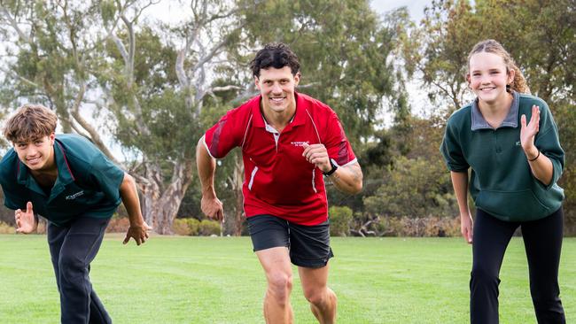 Monday 28th April 2025. Photo: John Evans preparing to race Blackwood High School students Felix Bokelmann (13) & Ayla Richardson (14). Stawell Gift winner and teacher John Evans returns to school. Picture: Tim Joy