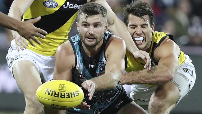 Sam Gray gets a handball away despite pressure from Alex Rance. Picture: Sarah Reed