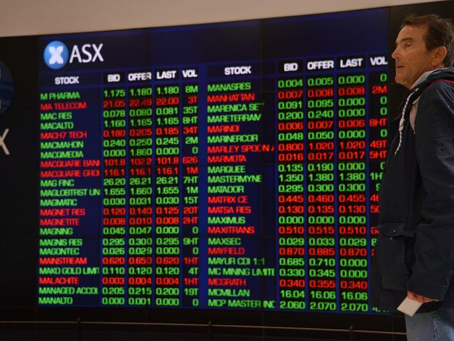 A visitor to the Australian Securities Exchange (ASX) looks at share prices on a big screen in Sydney on October 11, 2018. - The Australian share market joined the regional bloodbath after the sell off on Wall Street, plunging to a more than five-month low as all sectors dropped into the red. (Photo by PETER PARKS / AFP)