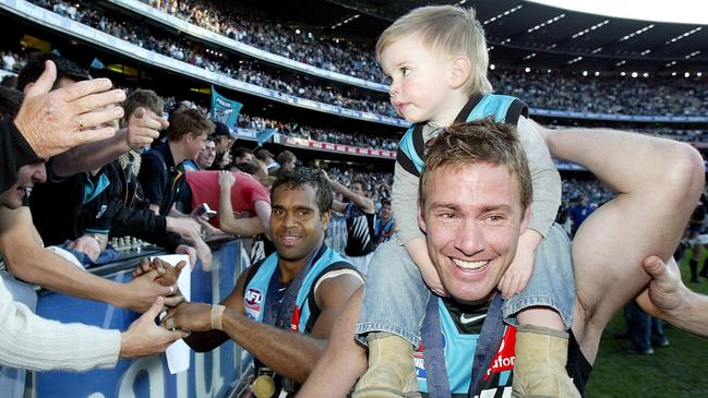 Taj Schofield on the shoulders of father Jarrad after Port Adelaide won the 2004 Grand Final.