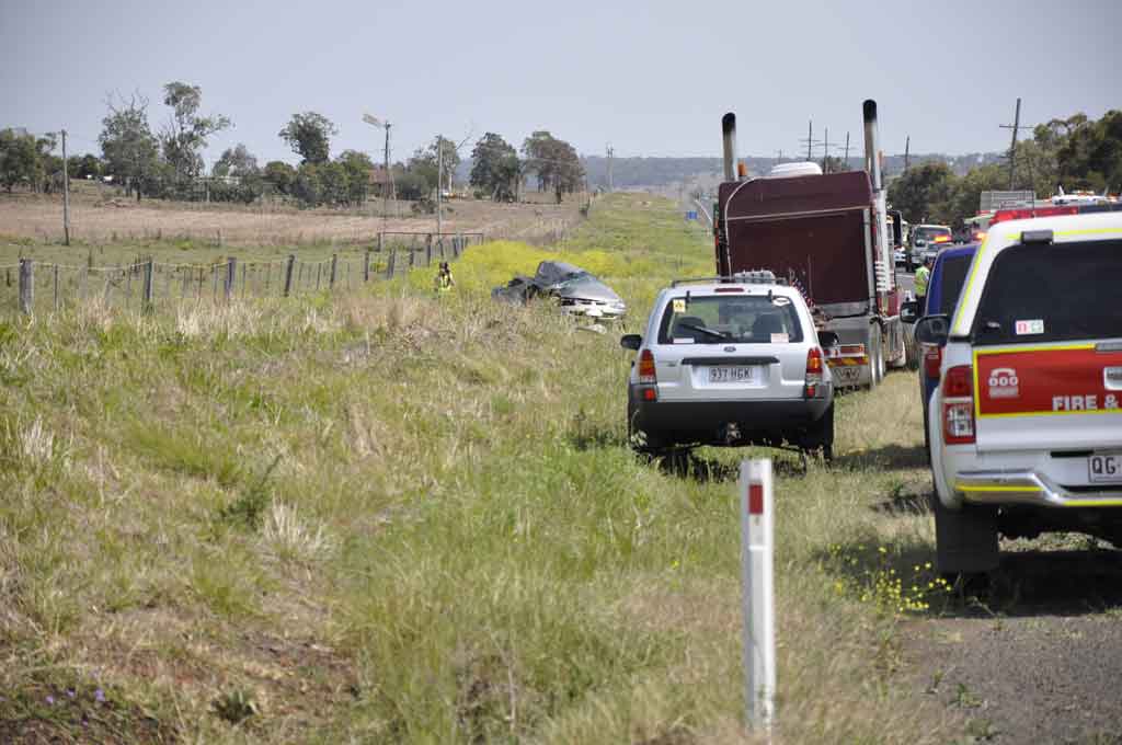 Emergency services at the scene of this morning's fatal traffic crash 20km west of Toowoomba on the Warrego Hwy.