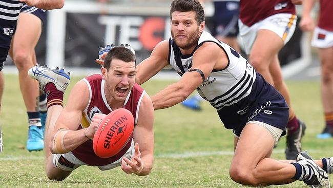 Darcy Barden fires out a handball under pressure from Scott Dowell. Picture: Josie Hayden