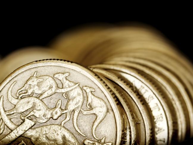 Australian one dollar coins over black background.