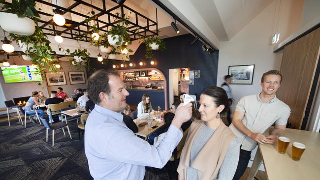 Operations manager Ross Adams taking a patrons temperature at the Torquay Hotel. Picture: Rob Leeson.