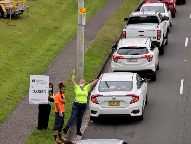 DAILY TELEGRAPH, JANUARY 9, 2022: Cars line up while staff hold up a closed sign at the end of the queue at the drive through Covid 19 testing clinic at Macquarie Park.Picture: Damian Shaw