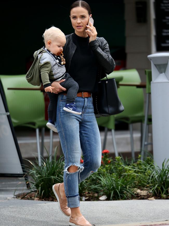 Brant kept it casual in a pair of ripped jeans and a black jacket while holding her son.