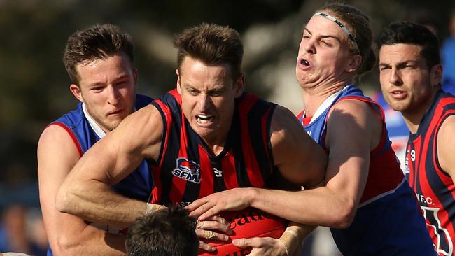 Champion Ryan Mullett (centre) tries to burst through for East Malvern. Picture: Hamish Blair