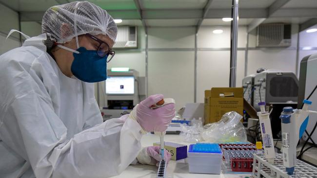 A health worker manipulates blood samples of COVID-19-infected patients at the laboratory of Anhembi emergency makeshift hospital in Sao Paulo, Brazil. Picture: AFP)