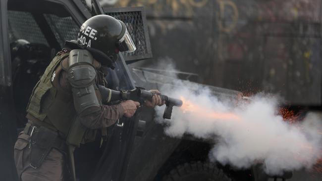 A riot police fires tear gas to disperse anti-government demonstrators in Santiago, as Chilean President Sebastian Pinera cancelled two major international summits after nearly two weeks of nationwide protests. Picture: AP