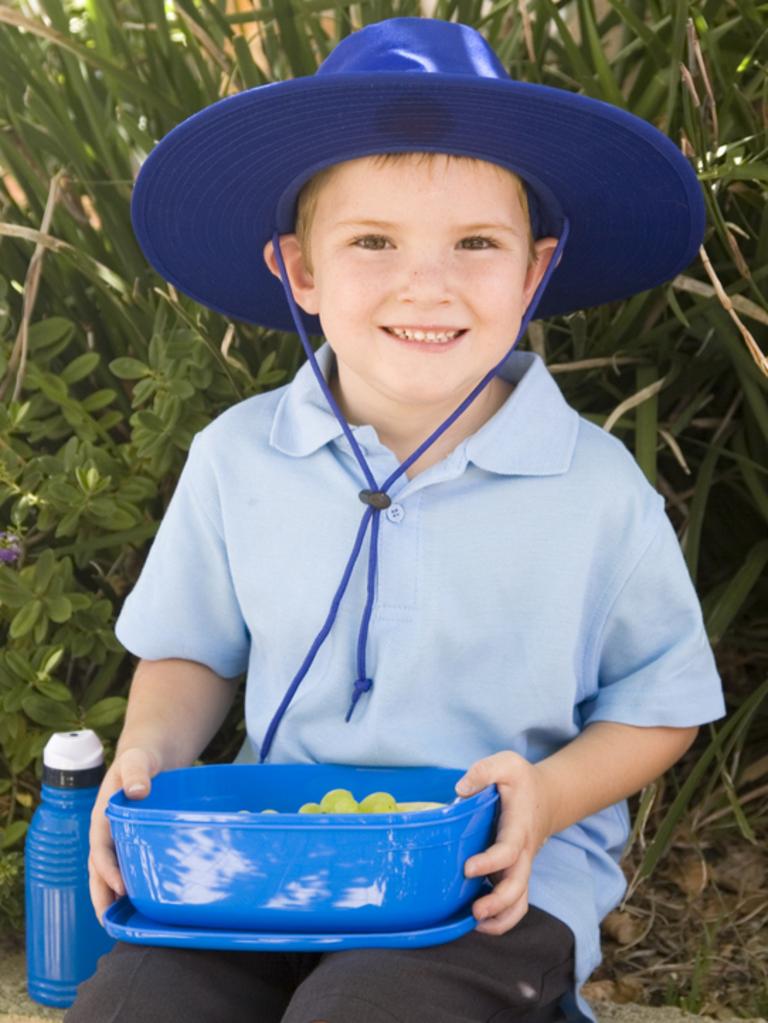 An Australian school boy eating lunch in the playground.